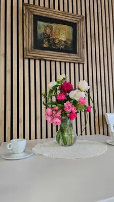 a vase filled with pink flowers on a table at Magnolija stan na dan in Belgrade