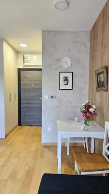 a living room with a table and flowers on a wall at Magnolija stan na dan in Belgrade