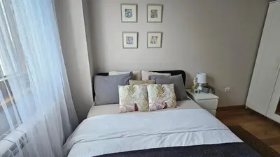 a bedroom with a bed with white sheets and pillows at Magnolija stan na dan in Belgrade