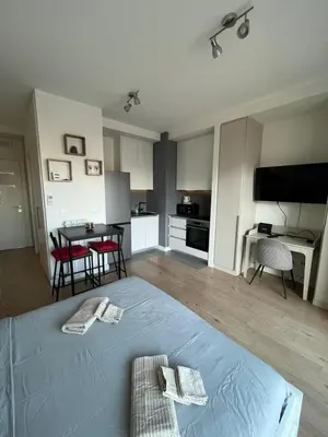 a bedroom with a bed and a kitchen with a table at Belgrade Waterfront Cozy Studio in Belgrade