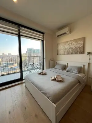 a bedroom with a large bed with two towels on it at Belgrade Waterfront Cozy Studio in Belgrade