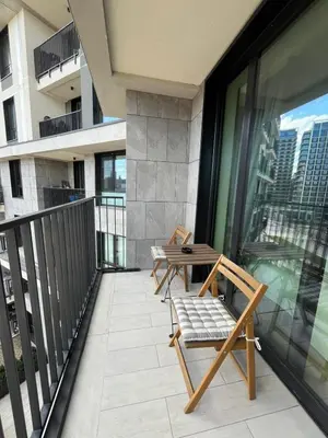 a balcony with two chairs and a table at Belgrade Waterfront Cozy Studio in Belgrade