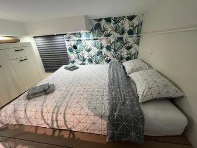 a bedroom with a bed with a pink and white comforter at Studio MB in Belgrade