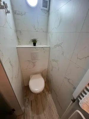 a small bathroom with a toilet and marble walls at Studio MB in Belgrade