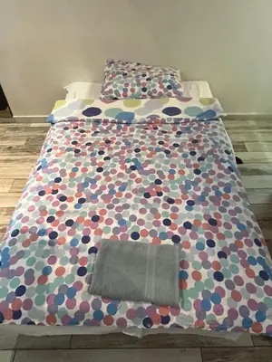 a bed with a comforter on top of it at Studio MB in Belgrade