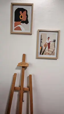 two framed pictures on a wall with two wooden chairs at Brod Trgovacka in Žarkovo