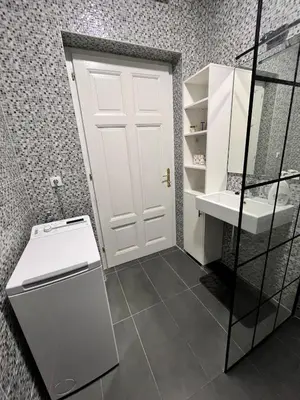 a bathroom with a white door and a sink at Apartment Ksenija in Belgrade