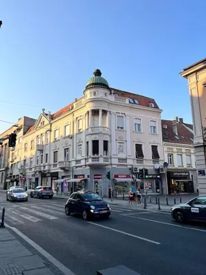 a building on a city street with cars parked on the street at Apartment Ksenija in Belgrade