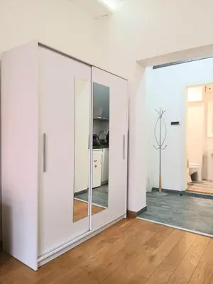 a large white wardrobe in a room with a wooden floor at Vlada in Belgrade
