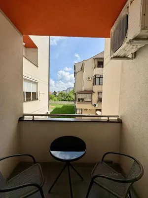 a balcony with two chairs and a view of a building at Stan Na Dan 111 in Inđija