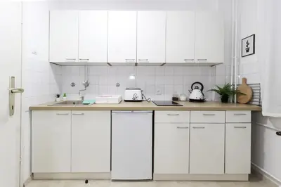 a white kitchen with white cabinets and a sink at Skroman, čist i udoban apartman u Ivana Ribara za dvoje in Belgrade