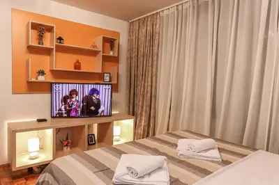 a bedroom with a bed and a tv on a shelf at Skroman, čist i udoban apartman u Ivana Ribara za dvoje in Belgrade