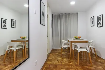 a dining room with two tables and a mirror at Skroman, čist i udoban apartman u Ivana Ribara za dvoje in Belgrade