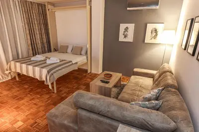 a living room with a couch and a bed at Skroman, čist i udoban apartman u Ivana Ribara za dvoje in Belgrade