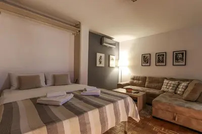 a bedroom with a large bed and a couch at Skroman, čist i udoban apartman u Ivana Ribara za dvoje in Belgrade