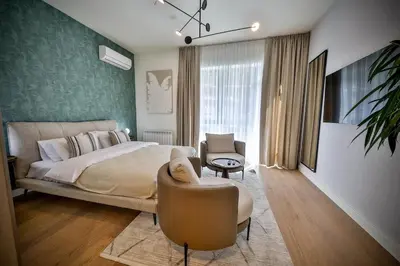 a bedroom with a large bed and a chair at ZIGZAG Belgrade Waterfront Scala in Belgrade