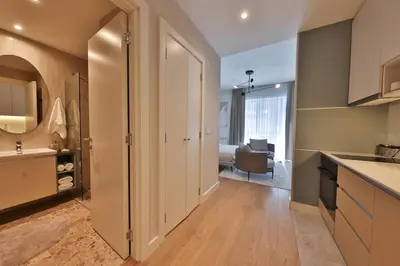 a kitchen with a door leading to a living room at ZIGZAG Belgrade Waterfront Scala in Belgrade
