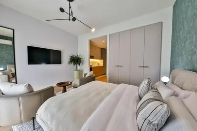 a bedroom with a large bed and a living room at ZIGZAG Belgrade Waterfront Scala in Belgrade