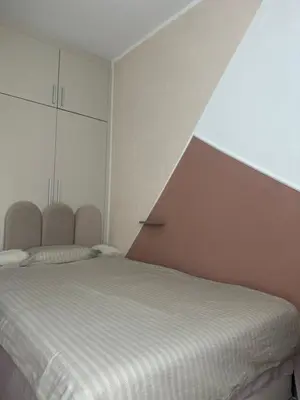 a white bedroom with a bed and a white wall at Silent hill apartment in Belgrade