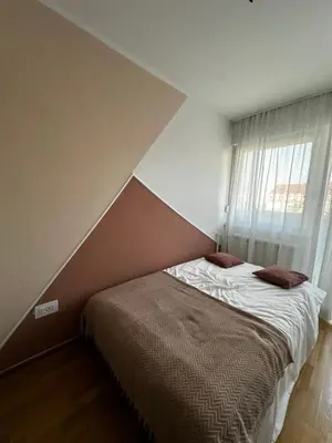 a bed in a bedroom with a large window at Silent hill apartment in Belgrade