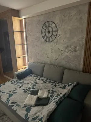 a bedroom with a bed with a clock on the wall at Apartman MINA in Kalugjerica