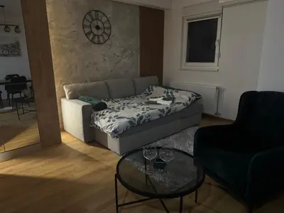 a living room with a couch and a glass table at Apartman MINA in Kalugjerica