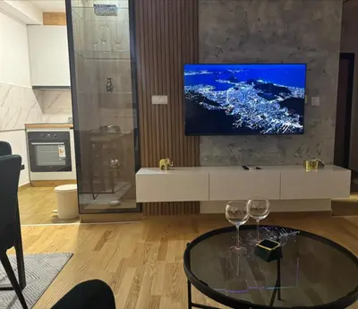a living room with a tv and two wine glasses at Apartman MINA in Kalugjerica