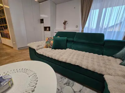a living room with a green couch and a table at Sun lux in Belgrade