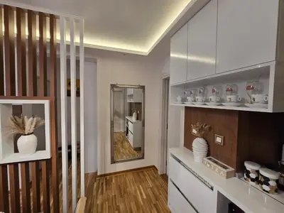 a kitchen with white cabinets and a mirror at Sun lux in Belgrade