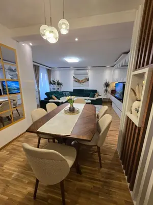 a dining room and living room with a table and chairs at Sun lux in Belgrade