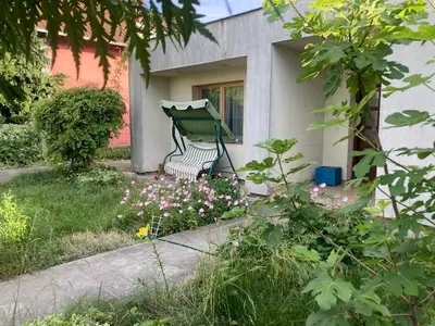 a green bench sitting in front of a house at Artists Inn, large 2 bed duplex apartment, parking in Železnička Stanica Zemunsko Polje