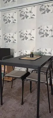 a black table with two chairs in front of a wall at Kucica Slobodica in Bukorovac