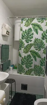a bathroom with a shower curtain and a tub at Kucica Slobodica in Bukorovac