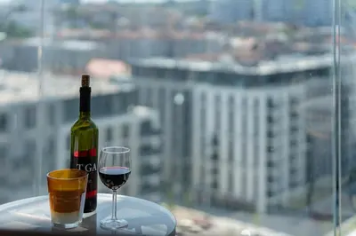 a bottle of wine and a glass on a table at 4 bedroom luxury apartment with park & river view in Belgrade
