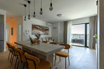 a kitchen and dining room with a table and chairs at 4 bedroom luxury apartment with park & river view in Belgrade
