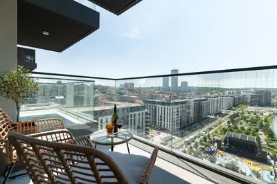 a balcony with a table and chairs and a view of a city at 4 bedroom luxury apartment with park & river view in Belgrade