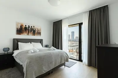 a bedroom with a bed and a large window at 4 bedroom luxury apartment with park & river view in Belgrade