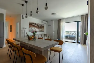 a kitchen and dining room with a table and chairs at 4 bedroom luxury apartment with park & river view in Belgrade