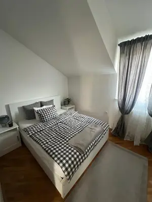 a white bedroom with a bed and a window at Joker 5 in Belgrade
