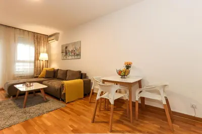 a living room with a couch and a table and chairs at Lavina 2 apartman u Belvilu, Novi Beograd, parking 5eur-dan in Novi Beograd