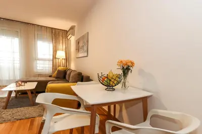 a living room with a couch and a table and chairs at Lavina 2 apartman u Belvilu, Novi Beograd, parking 5eur-dan in Novi Beograd