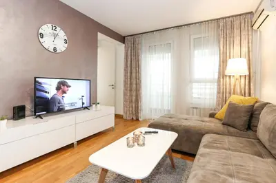 a living room with a couch and a tv at Lavina 2 apartman u Belvilu, Novi Beograd, parking 5eur-dan in Novi Beograd