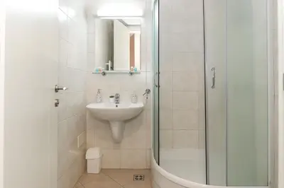 a white bathroom with a sink and a shower at Lavina 2 apartman u Belvilu, Novi Beograd, parking 5eur-dan in Novi Beograd