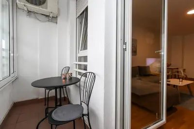 a small table and chairs in a small room with a window at Lavina 2 apartman u Belvilu, Novi Beograd, parking 5eur-dan in Novi Beograd