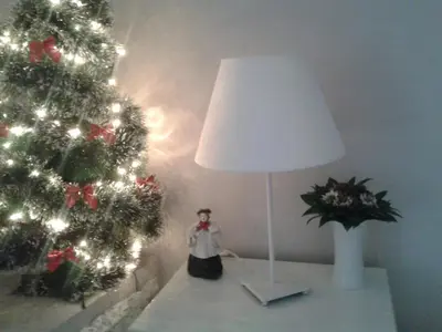 a table with a lamp and a christmas tree at Apartment Bella Vista in Belgrade