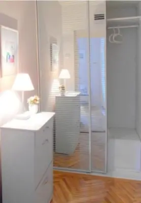 a bathroom with a shower and a desk with a lamp at Apartment Bella Vista in Belgrade