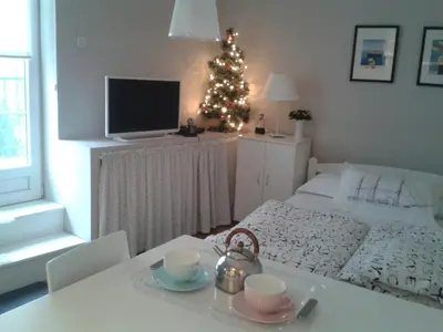 a bedroom with a christmas tree and a table with cups at Apartment Bella Vista in Belgrade