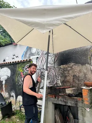 a man is standing under an umbrella at Hostel Fair and Square in Belgrade