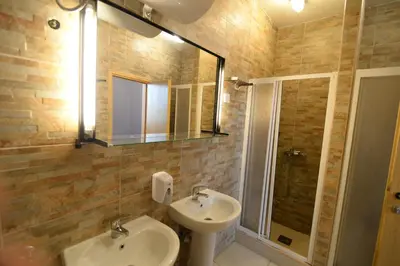a bathroom with a sink and a toilet and a mirror at Hostel Fair and Square in Belgrade