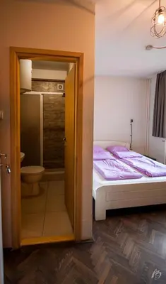 a small bedroom with a bed and a bathroom at Hostel Fair and Square in Belgrade